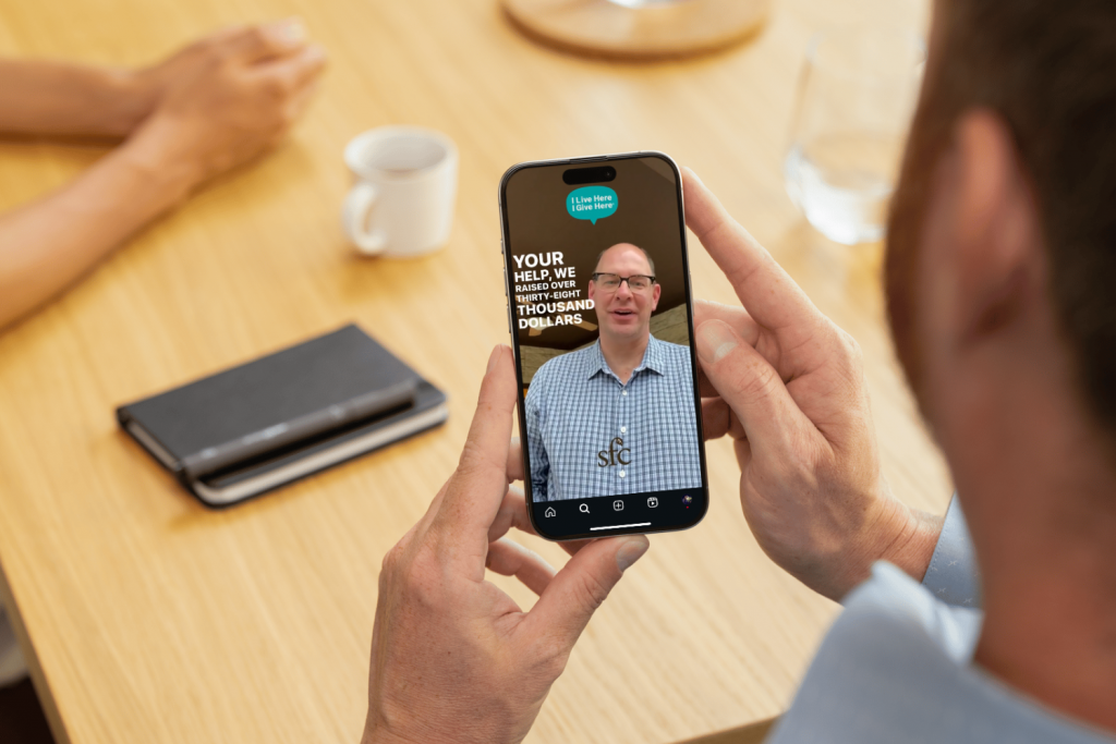 Man watching nonprofit thank-you video on smartphone as part of donor appreciation campaign