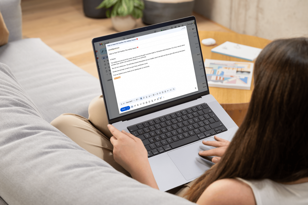Nonprofit worker typing email on computer to donors for email marketing campaign.