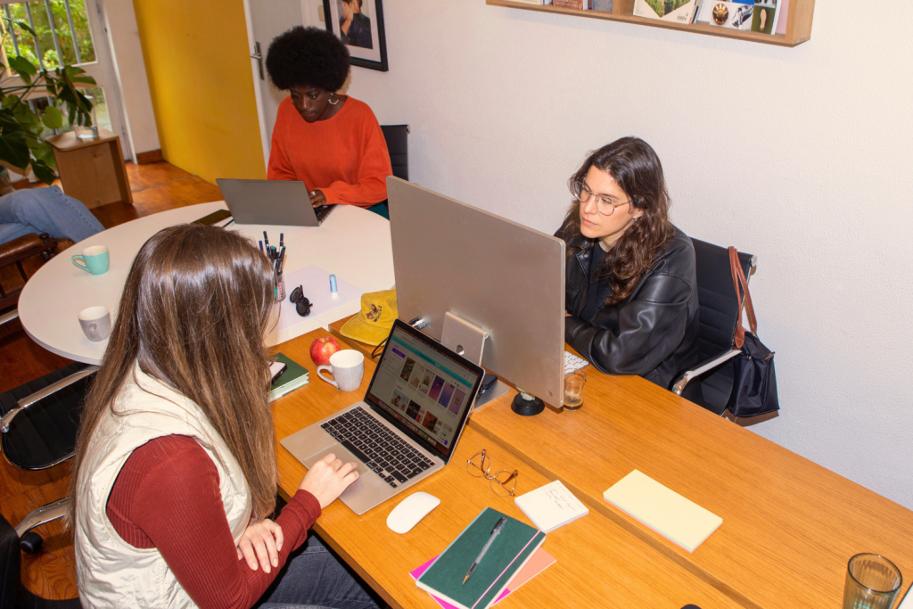 Equipo sin fines de lucro trabajando en una campaña de recaudación de fondos digital en computadoras.